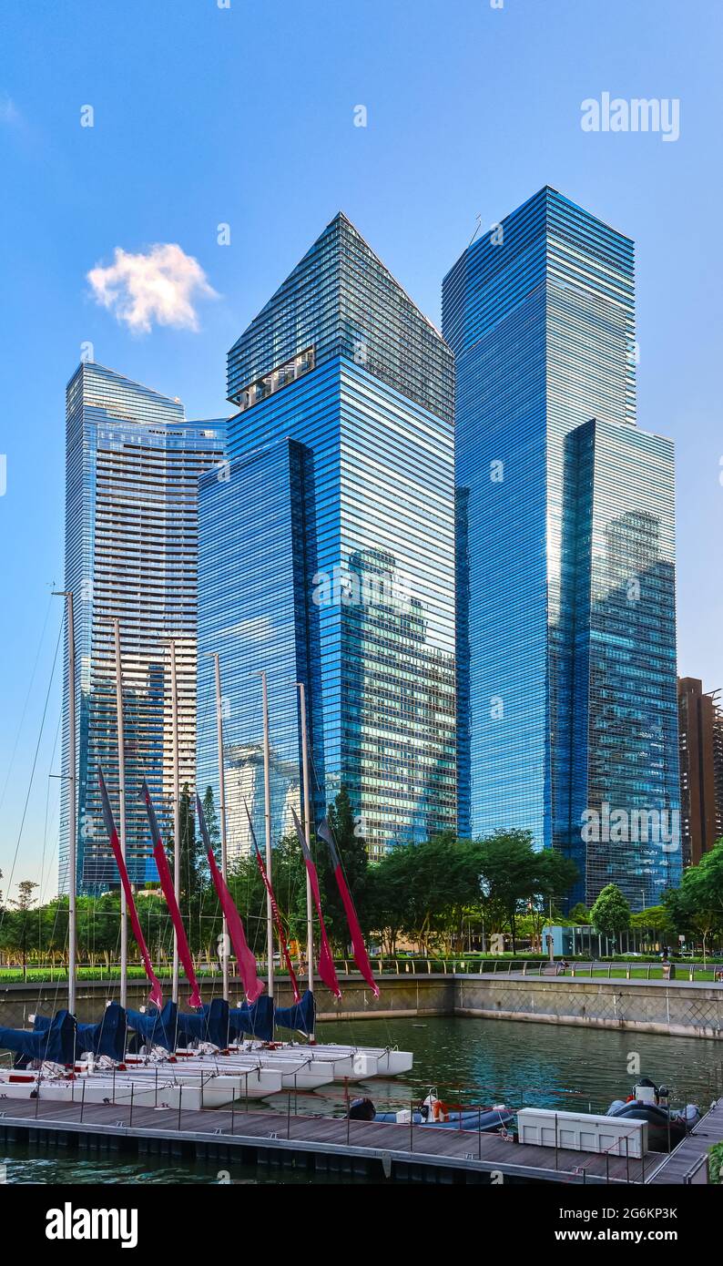 Group of buildings in CBD or Central Business District over Marina Bay waters and catamaran boat jetty in day light, Singapore. Stock Photo
