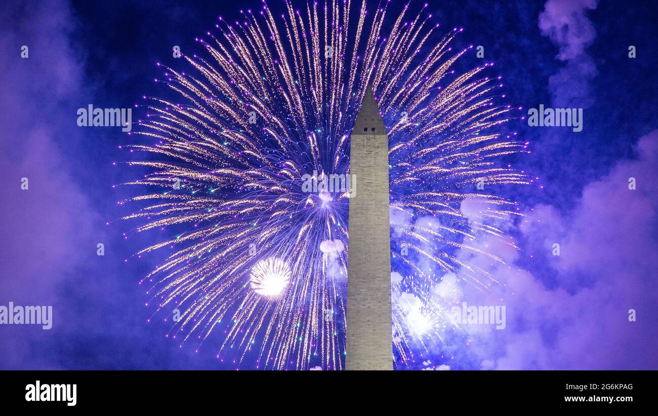 Fireworks behind the Washington Monument on July 4, 2021.  Viewed from the National Mall, between the Washington Monument and the Capitol building. Stock Photo