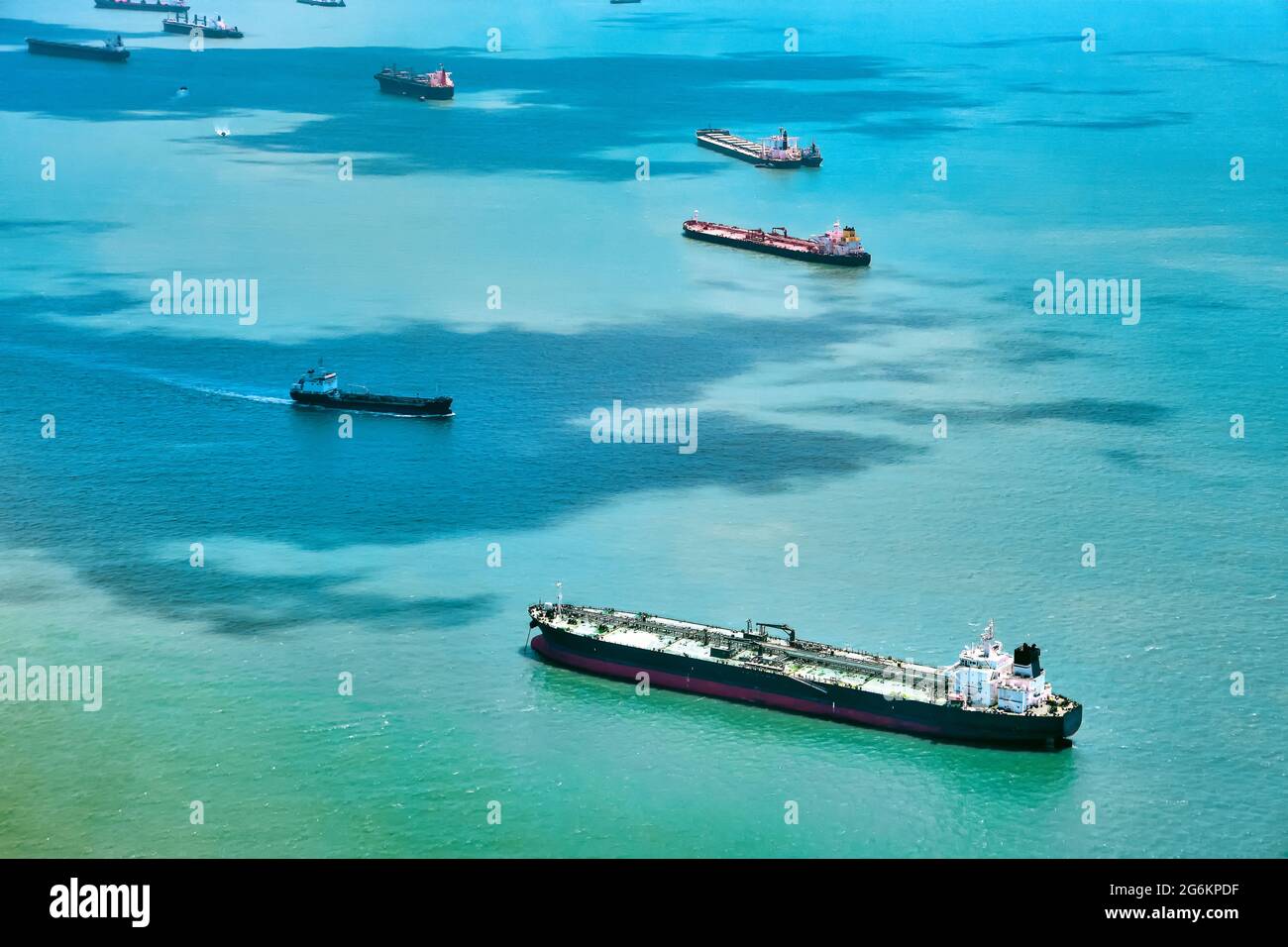 Aerial view of container ships in Singapore Strait. Airplane shot. Cargo ships anchored in the road, waiting to enter the busiest port in region.  Stock Photo
