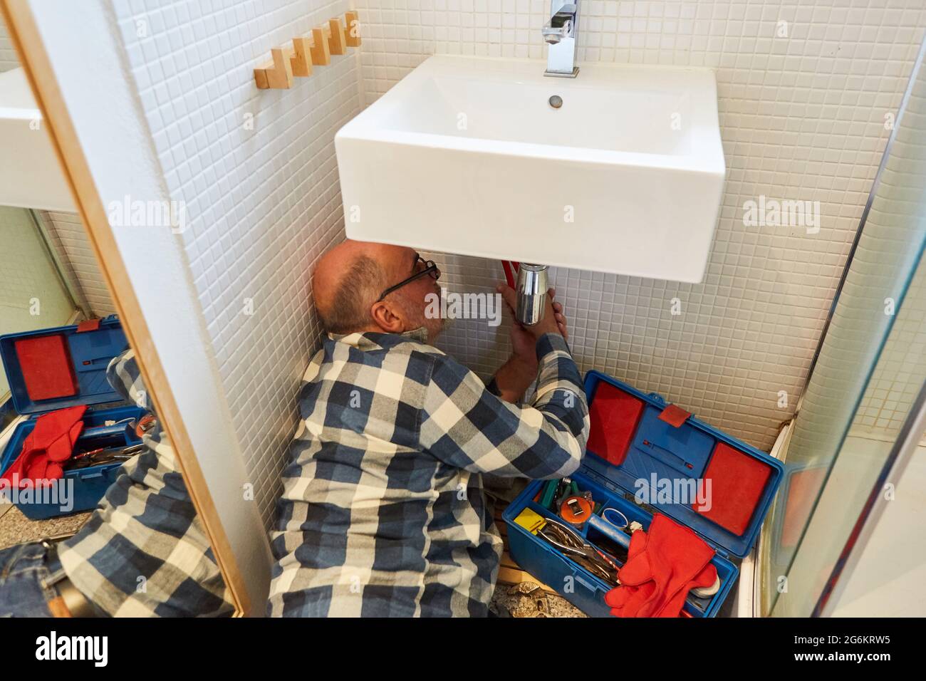 Plumber or do-it-yourselfer installs or assembles new wash basin in the bathroom Stock Photo