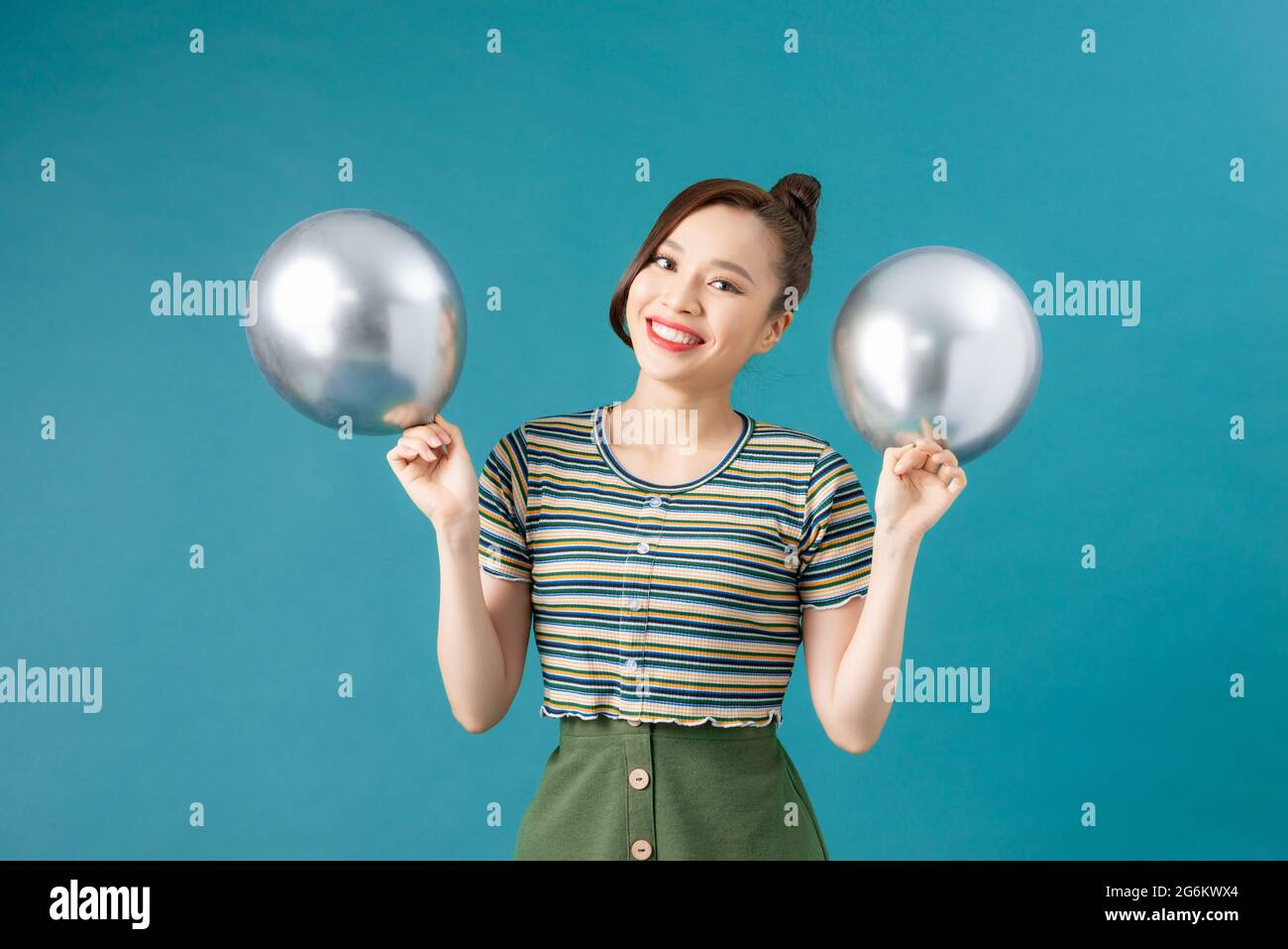 Happy asian girl play with silver balloons Stock Photo - Alamy