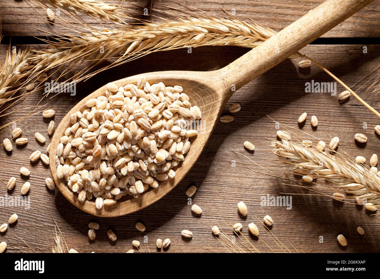Close up of wheat seed in spoon on old wooden table. This file is cleaned and retouched. Stock Photo