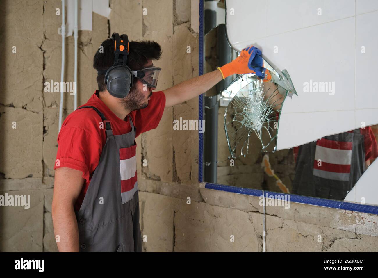 Builder removing a mirror from a wall. House renovation Stock Photo Alamy