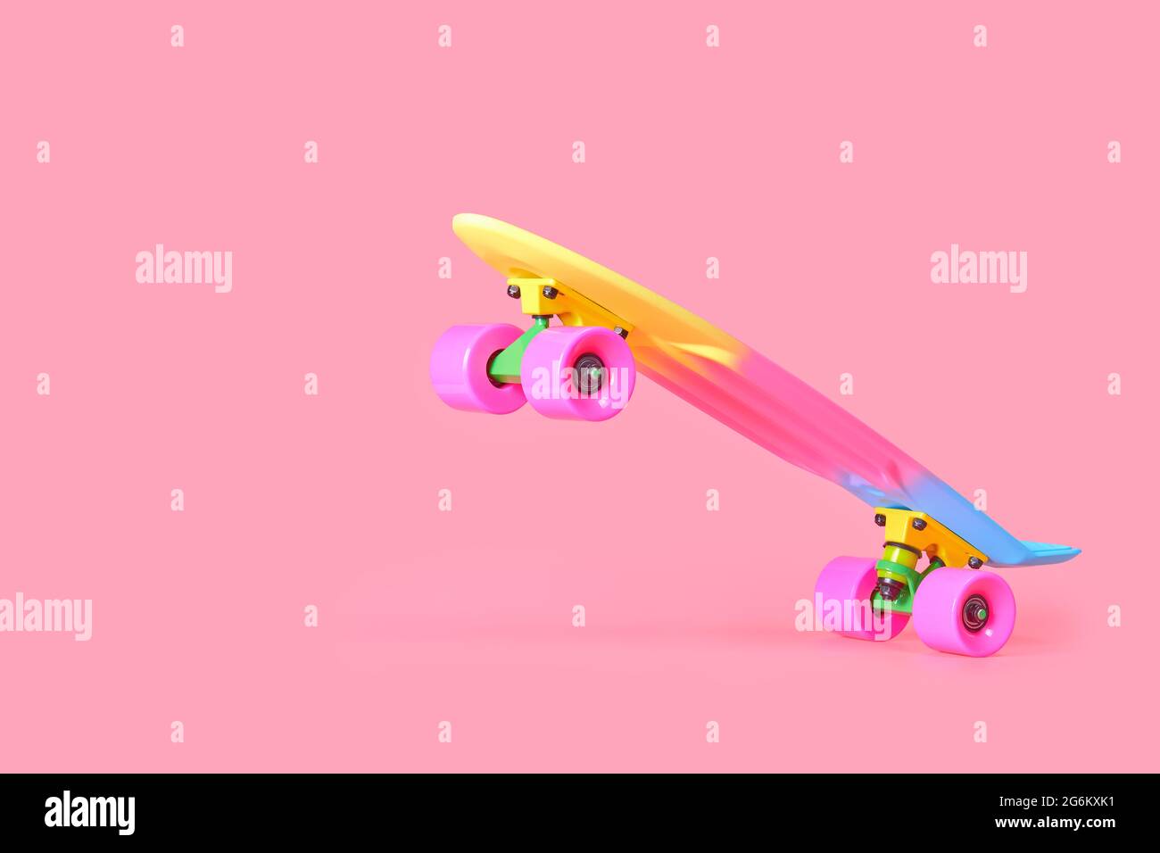 rainbow plastic Penny board skateboard isolated on pink background