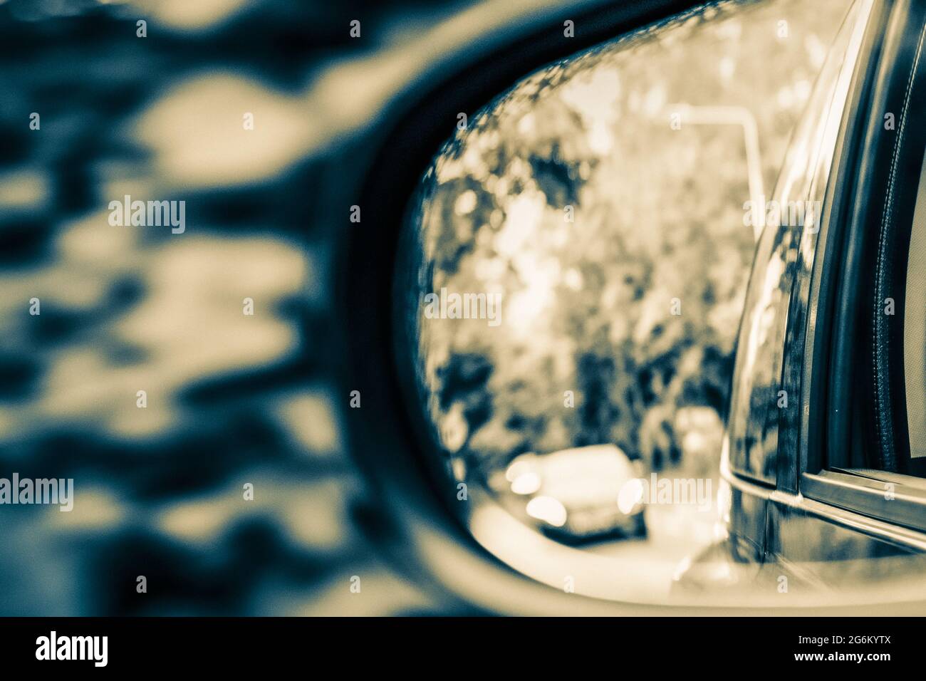 View through a wing mirror of cars behind in a split black and white tone Stock Photo