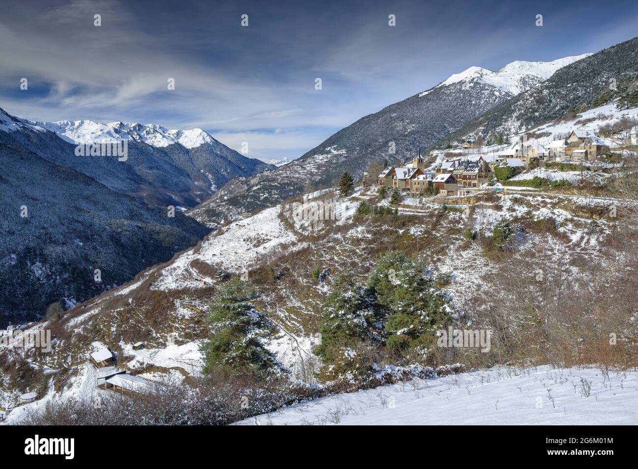 Snowy Aran Valley in winter, seen from the village of Mont. In the foreground, Montcorbau village (Aran Valley, Catalonia, Spain, Pyrenees) Stock Photo