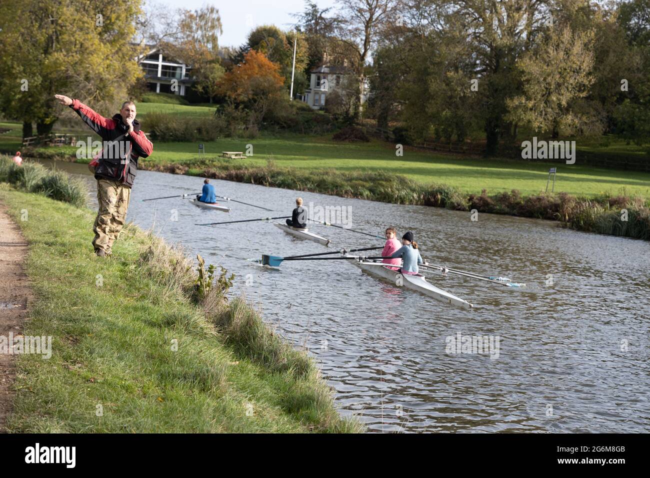 Starter and a line of scullers rowing in a local rowing race on the river Cam near Fen Ditton Cambridge Stock Photo
