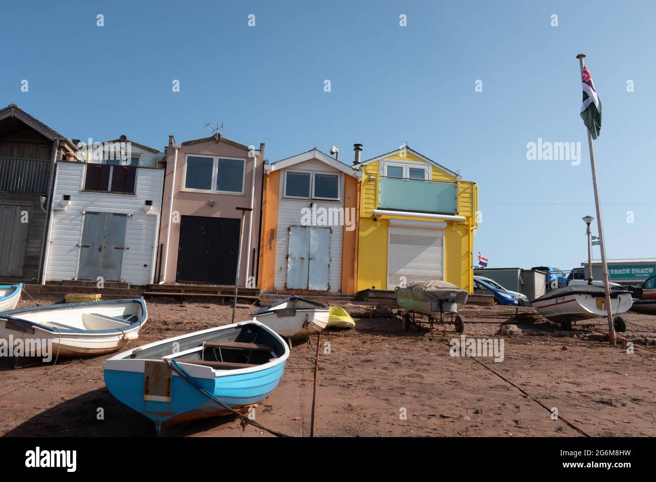 Brightly coloured beach huts and boats at the inner beach in Teignmouth South Devon England Stock Photo