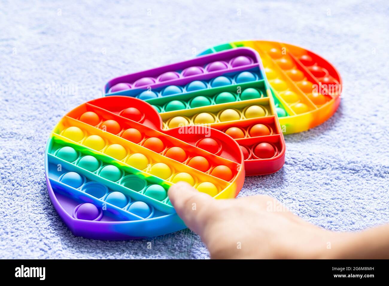 Kids popular antistress toys pop it with index finger over bubble on blue  blanket Stock Photo - Alamy