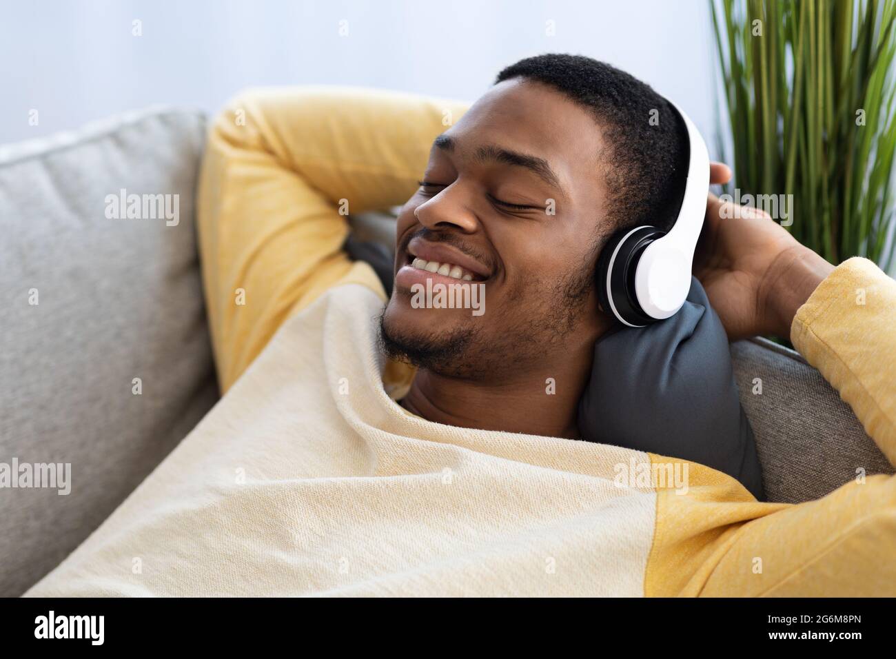 Closeup of relaxed black guy listening to music, using headset Stock ...