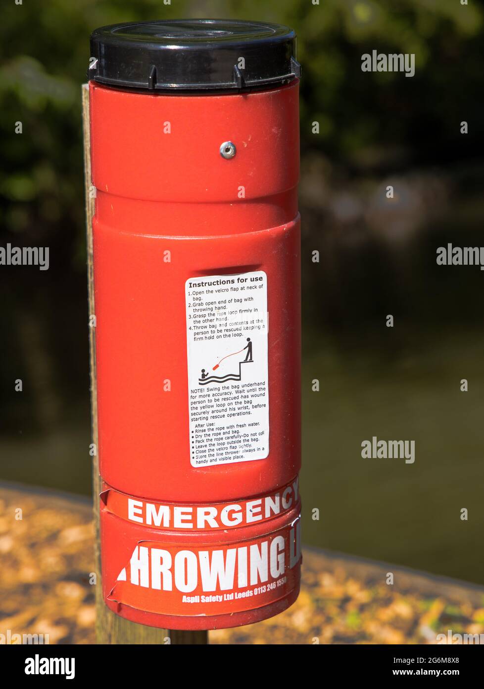 A red canister container holding a water safety thrown line shown diagram how the device should be used Stock Photo