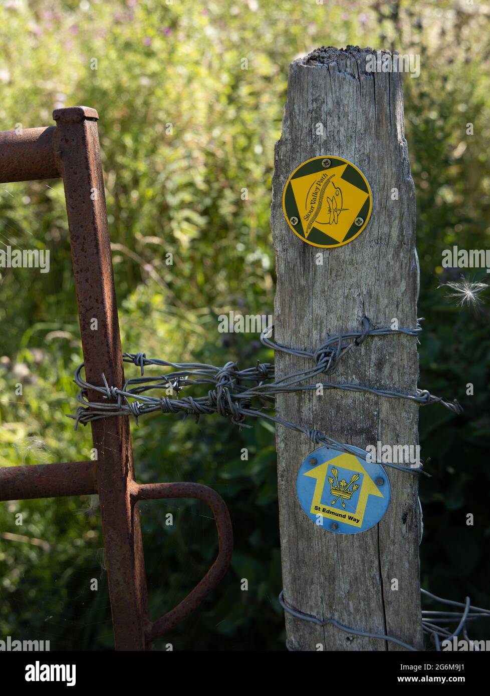 St Edmund Way a long distance walking route signs on wooden post with barbed wire. A route across Suffolk, Stour Valley Path (East Anglia) England Stock Photo