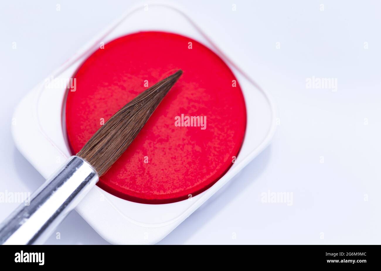 The image shows red watercolor isolated with brush on white background ...
