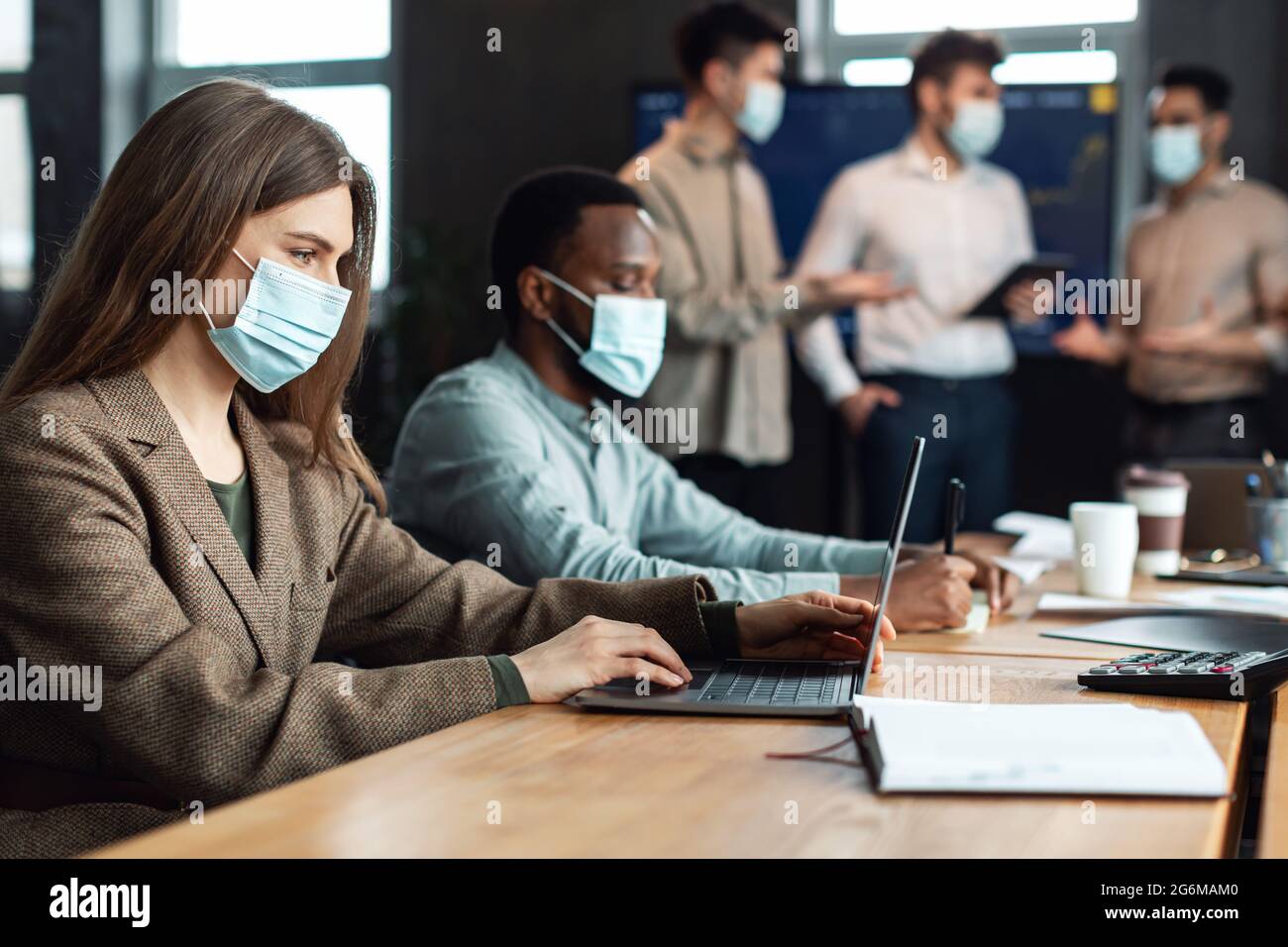 Colleagues having meeting in boardroom, working on project using pc Stock Photo