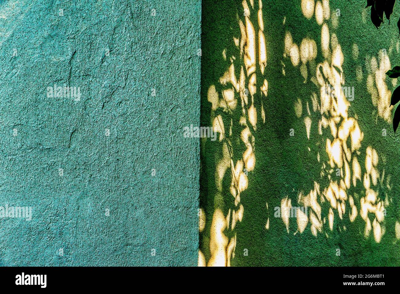 Sharp corner of a concrete wall with the sunlight forming patterns on one side Stock Photo