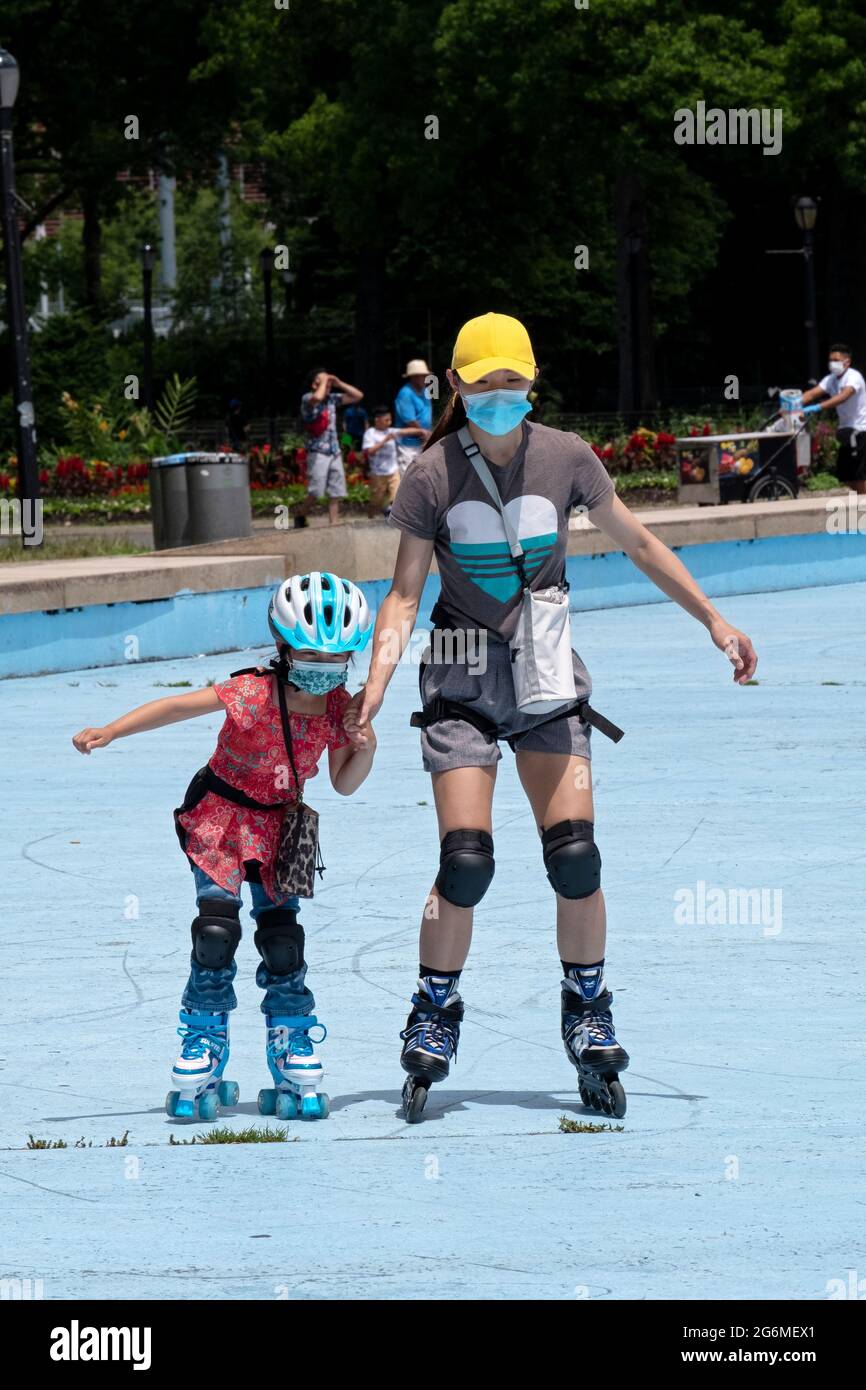 An Asian American mother teaches her daughter to roller skate. In A