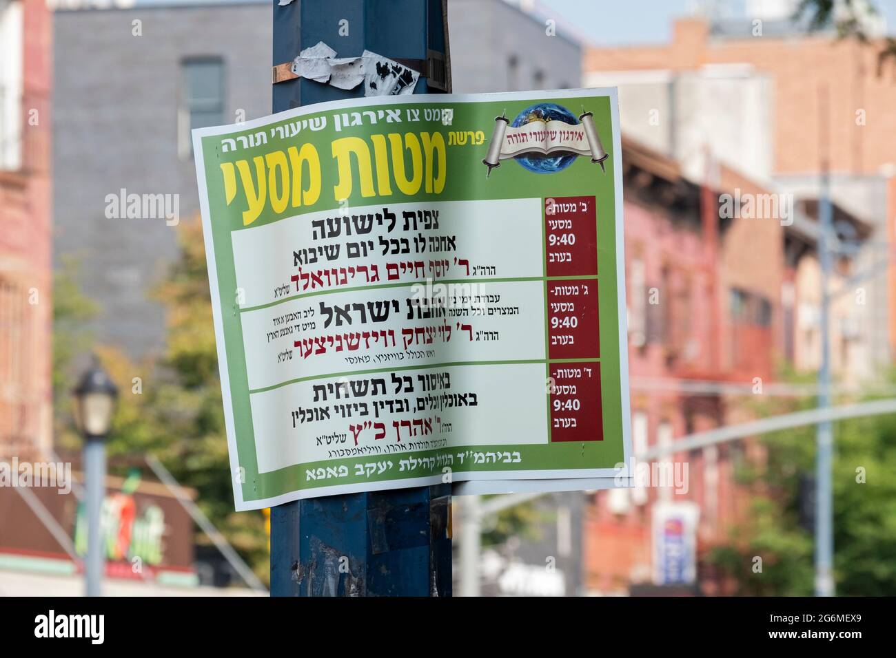 A Hebrew & Yiddish sign on Lee Avenue listing a series of lectures on the next weekly Torah reading sponsored by the pupa hasidic group. In Brooklyn. Stock Photo