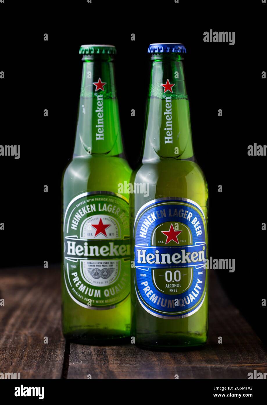 LONDON, UK - APRIL 27, 2018: Bottles of Heineken original and Alcohol free Lager Beer on dark wooden background. Heineken is the flagship product of H Stock Photo