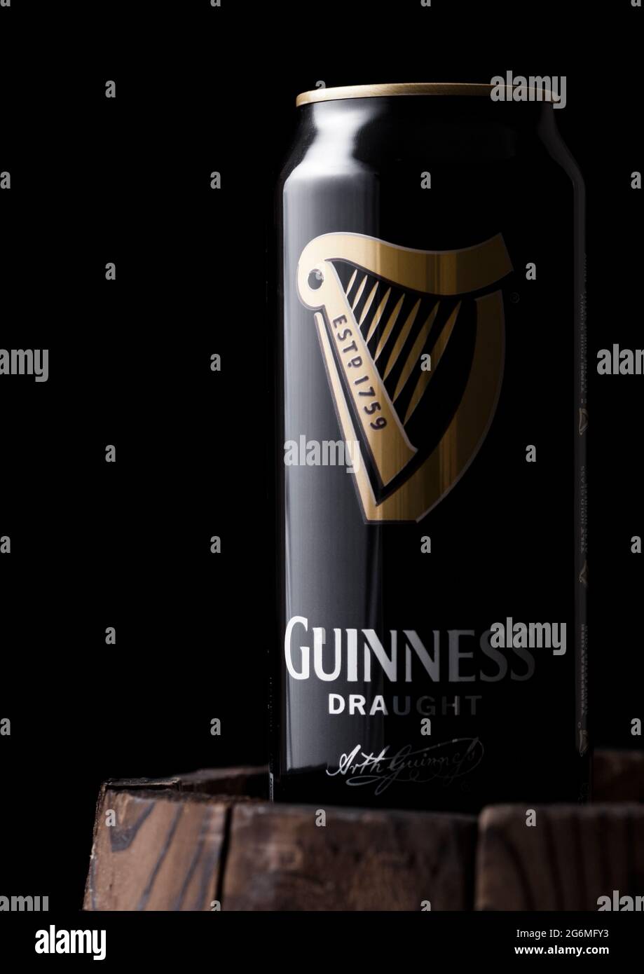 LONDON, UK - APRIL 27, 2018: Aluminium can of Guinness draught stout beer on top of old wooden barrel. Guinness beer has been produced since 1759 in D Stock Photo