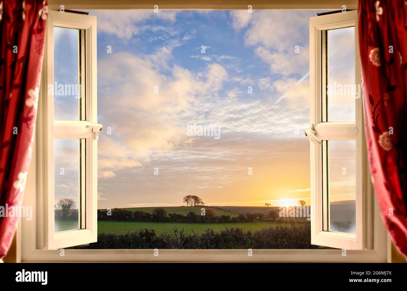 Stunning open window view onto a sunrise rural landscape in summer. Stock Photo