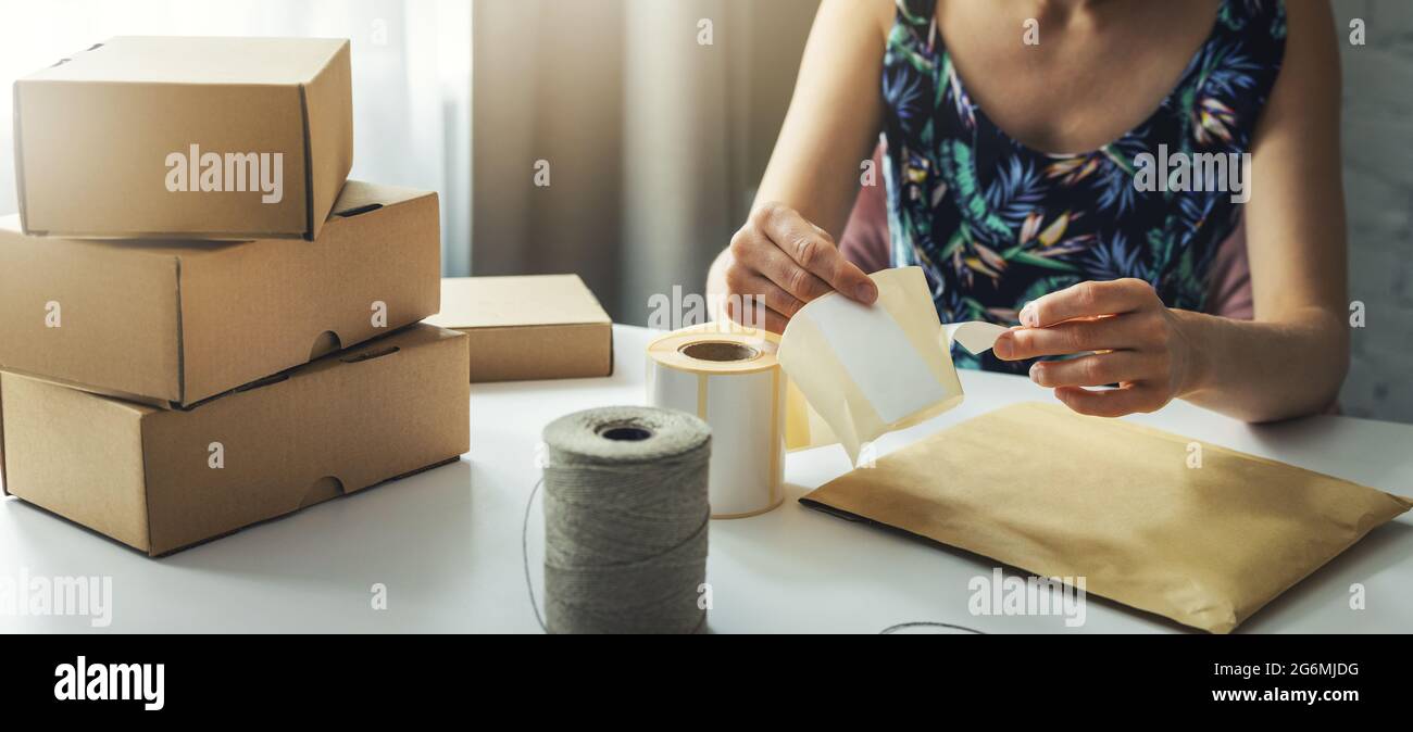 small online business owner preparing parcel shipping label at home for shipment delivery. banner Stock Photo
