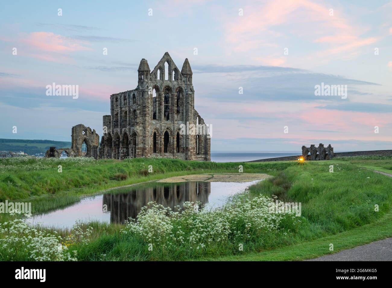 Whitby Abbey at sunrise reflected in the pond Stock Photo