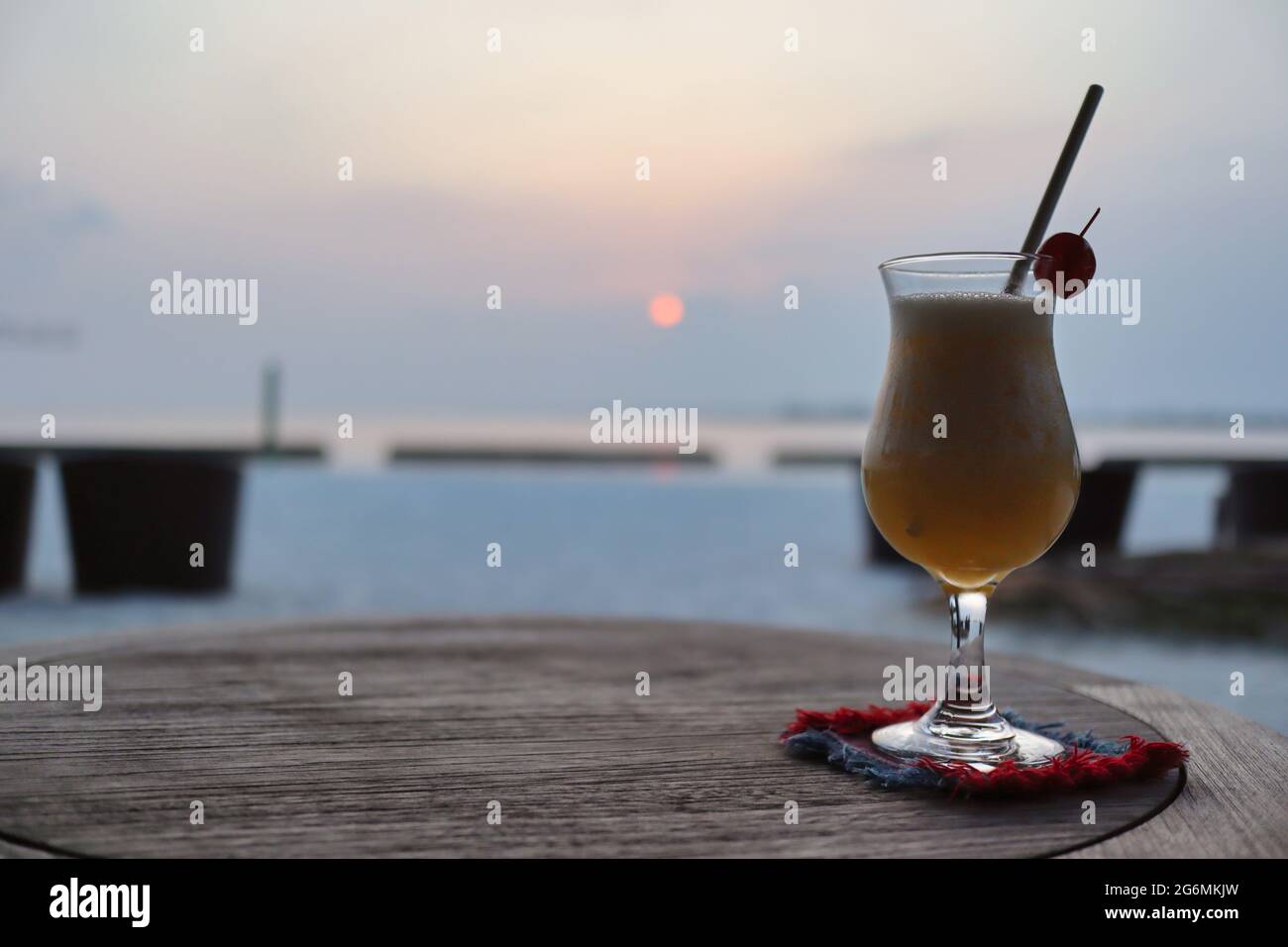 One Glass of Fruity Cocktail during Sunset in Maldives. Iced Beverage on Table in Maldivian Resort. Stock Photo