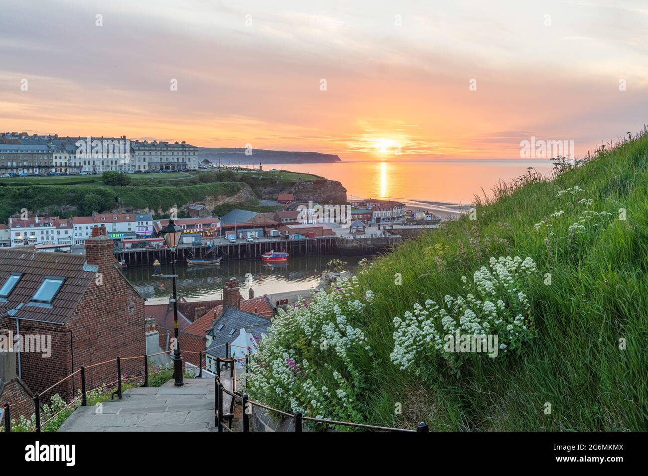 The sun sets over the horizon at the 199 Steps in Whitby Stock Photo