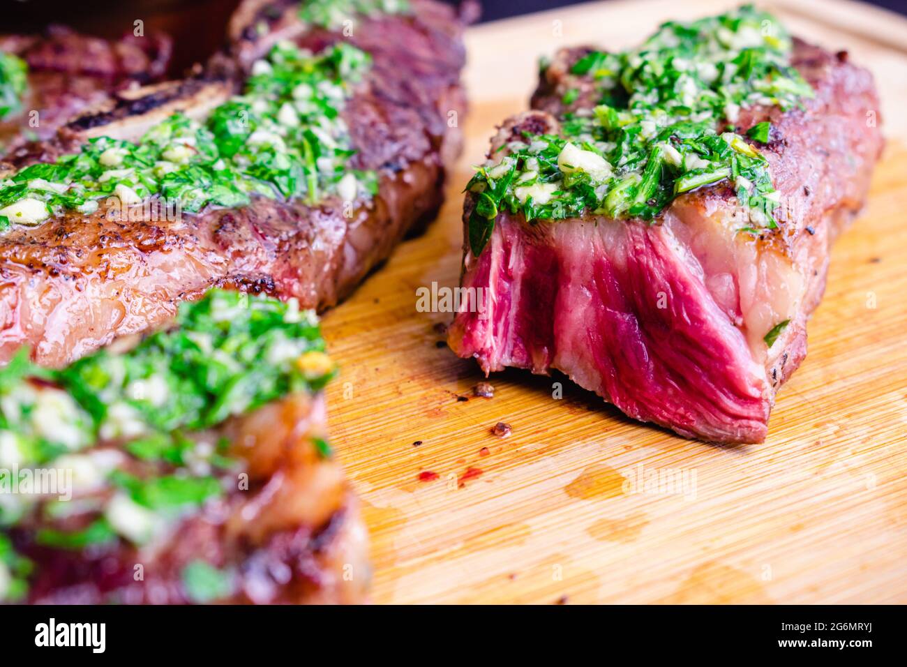 Argentinean-Style Grilled Short Ribs With Chimichurri: Barbecued flanken beef ribs on a bamboo cutting board Stock Photo