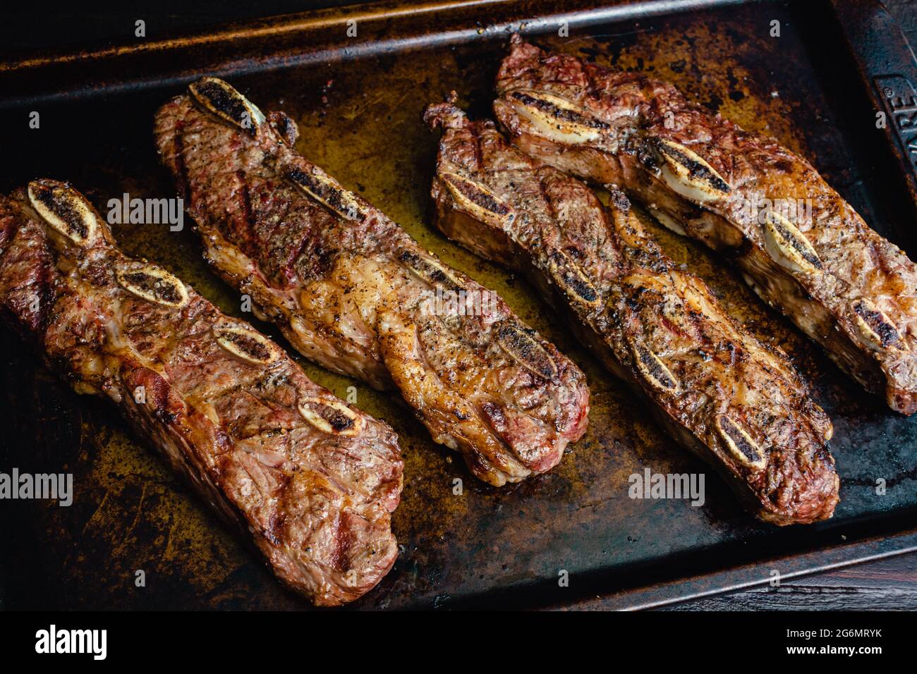 Grilled Beef Short Ribs on a Sheet Pan: Barbecue flanken beef ribs with a rustic background Stock Photo