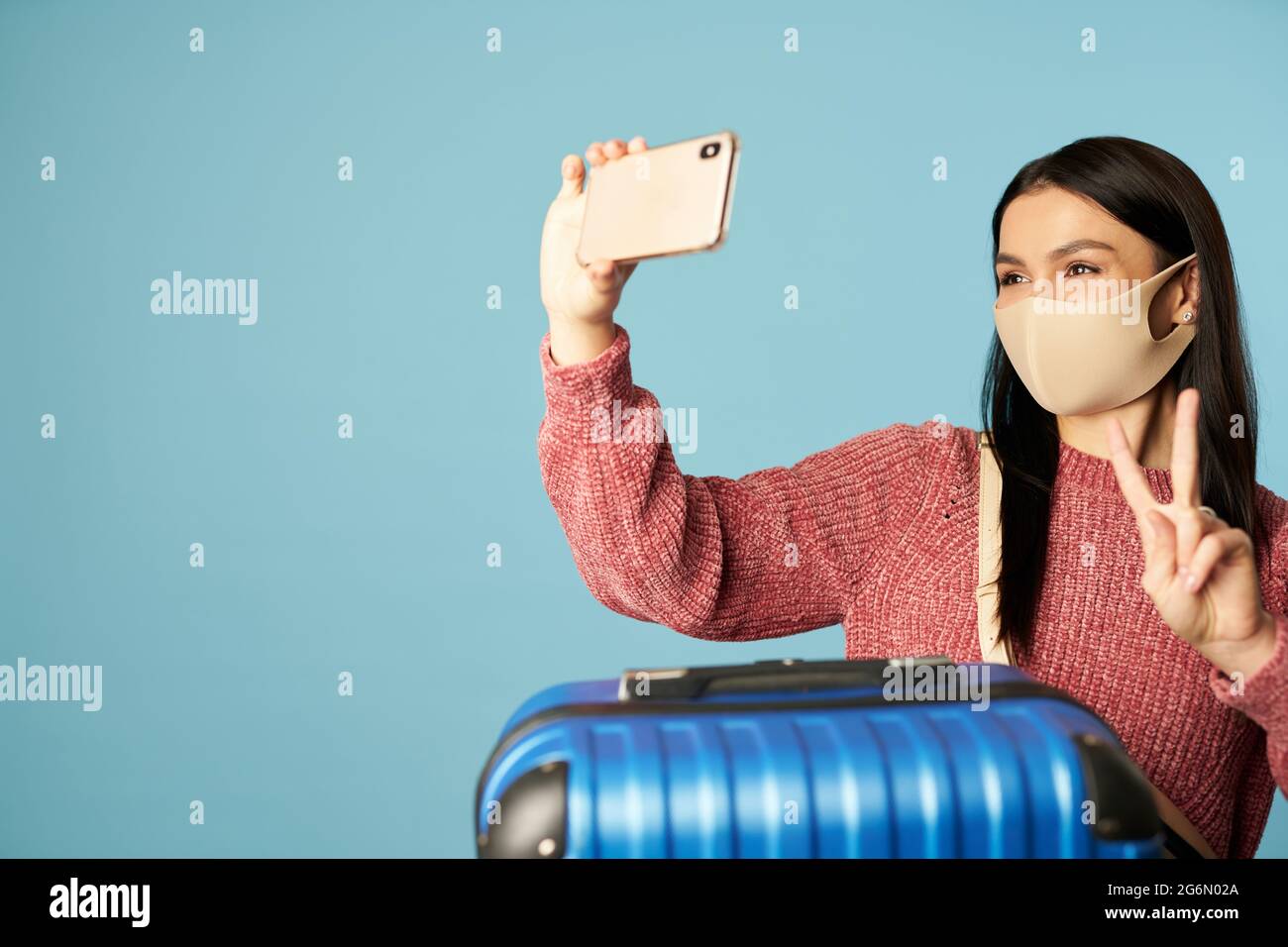 Young lady taking selfie while holding mobile phone Stock Photo