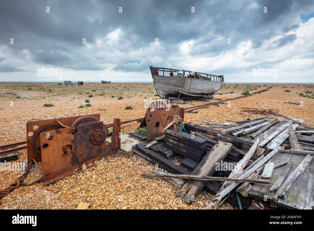 Wrecked fishing boat and collapsed shed on the shingle beach at ...