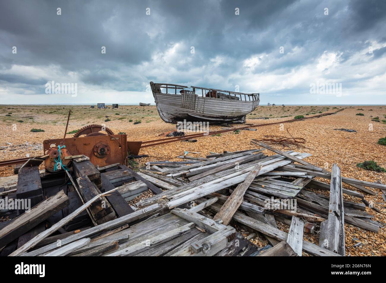 Wrecked fishing boat and collapsed shed on the shingle beach at ...