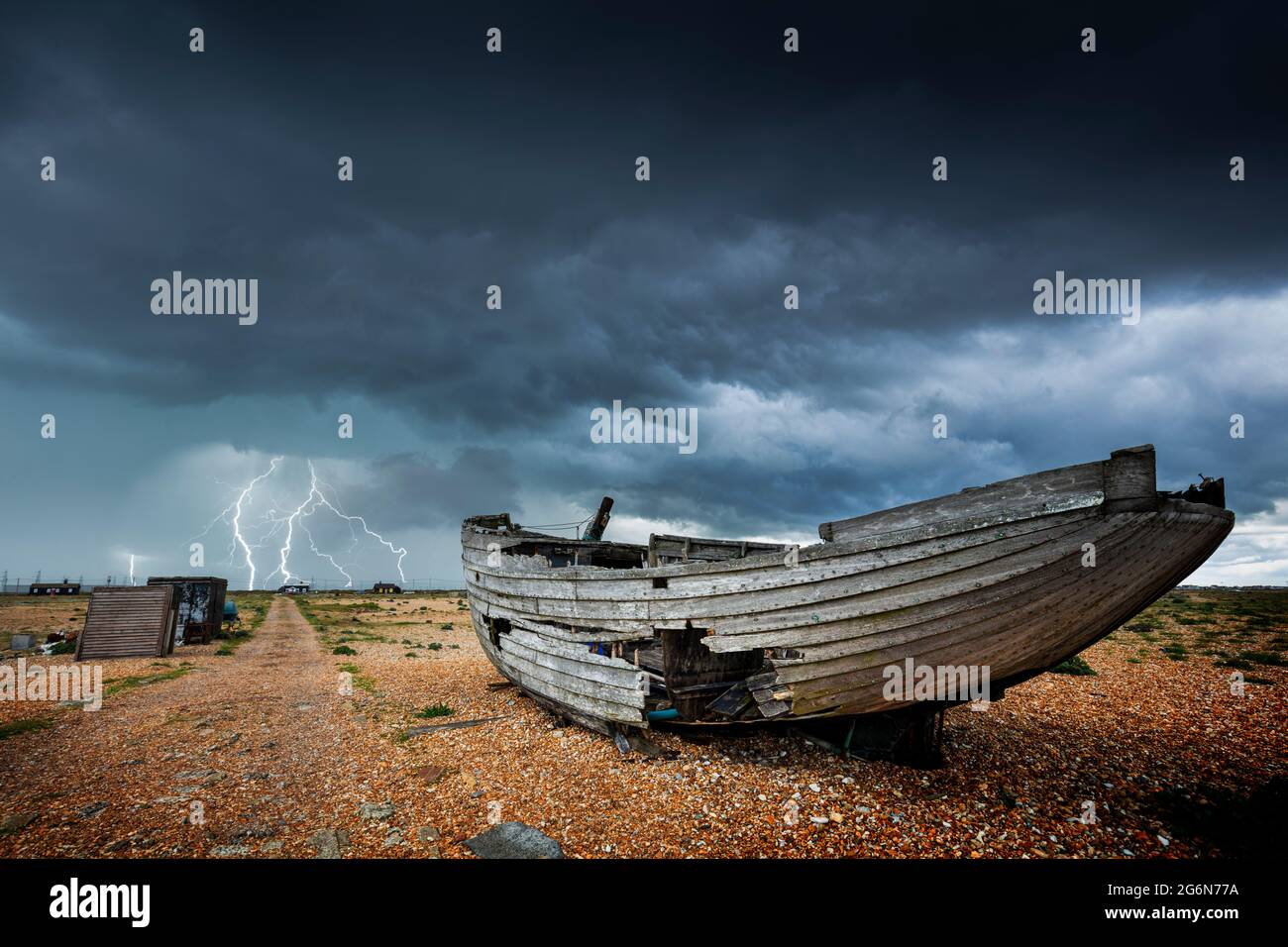 Wrecked boat in a storm on the shingle beach at Dungeness National Nature Reserve Kent England UK GB Europe Stock Photo