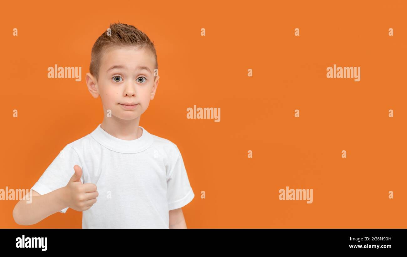Happy boy showing thumbs up gesture. Preschool boy holds his thumb up ...