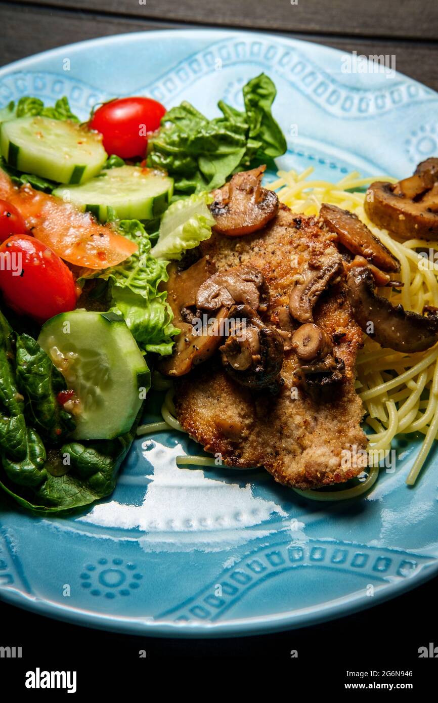 Italian veal marsala served over spaghetti with side garden salad Stock