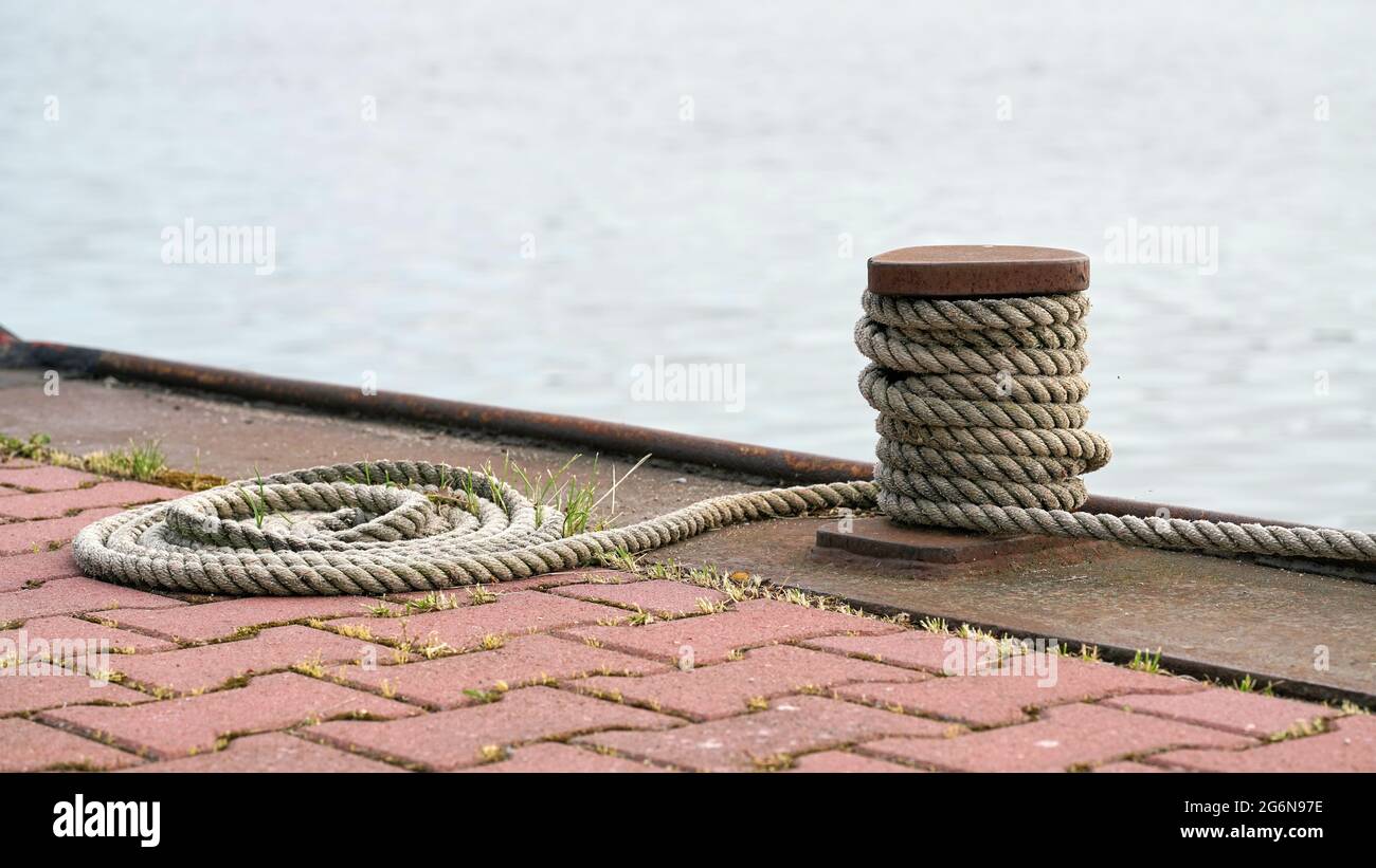Bollard and mooring rope from a moored ship on the Mittellandkanal near Magdeburg in Germany Stock Photo