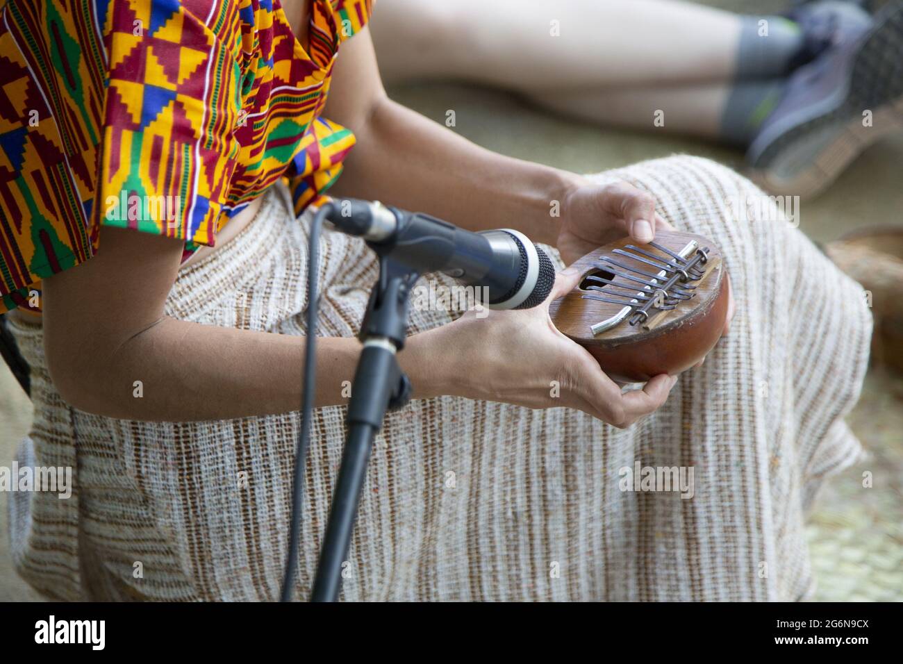 Female playing the kalimba near a microphone Stock Photo - Alamy