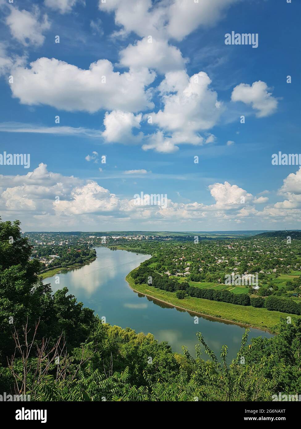 High angle, altitude view to the Nistru river bank, near Soroca city, Moldova. Idyllic vertical scene to the green valley with tiny houses in the file Stock Photo