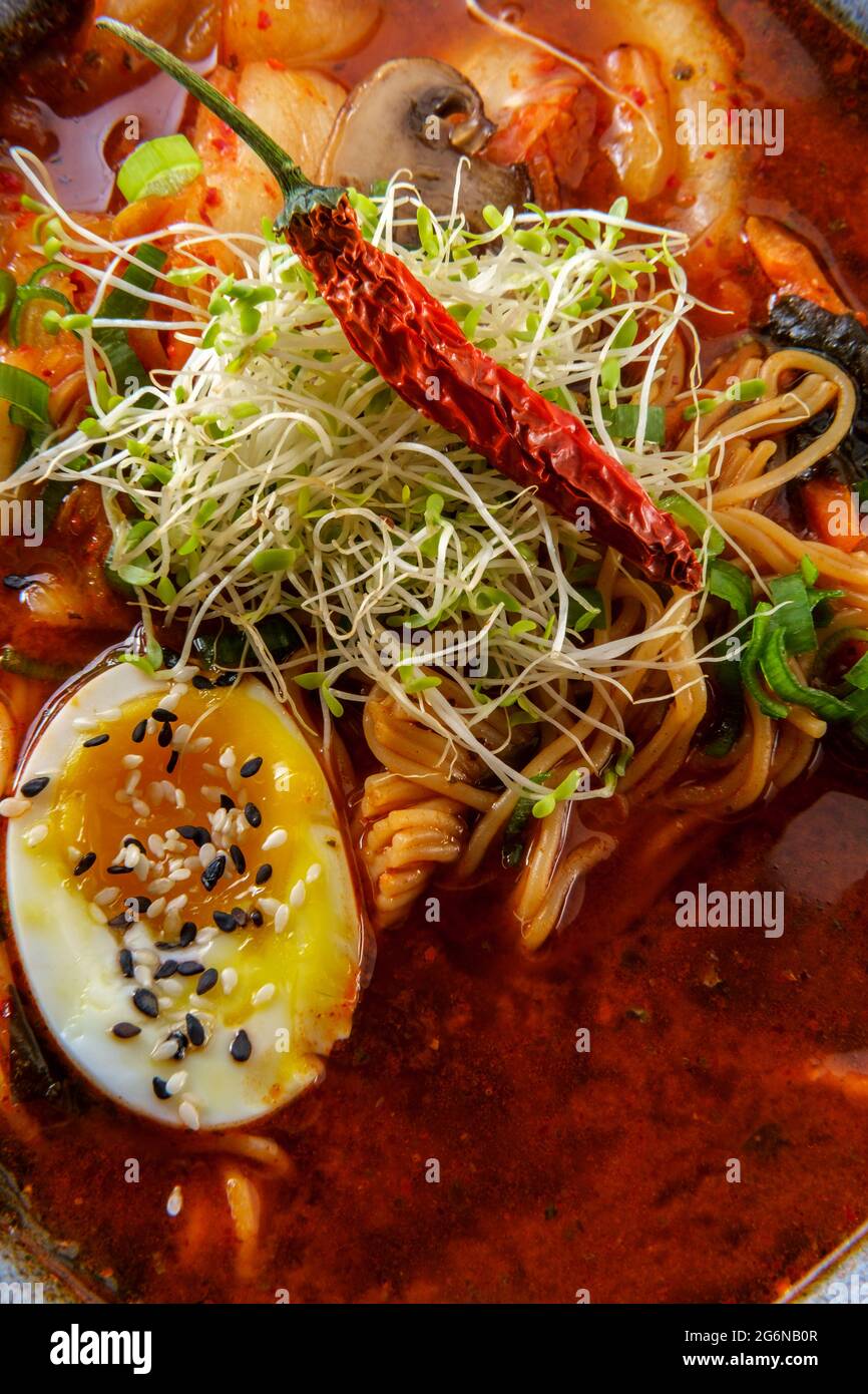 Korean kimchi ramen garnished with mushrooms scallions and a softboiled