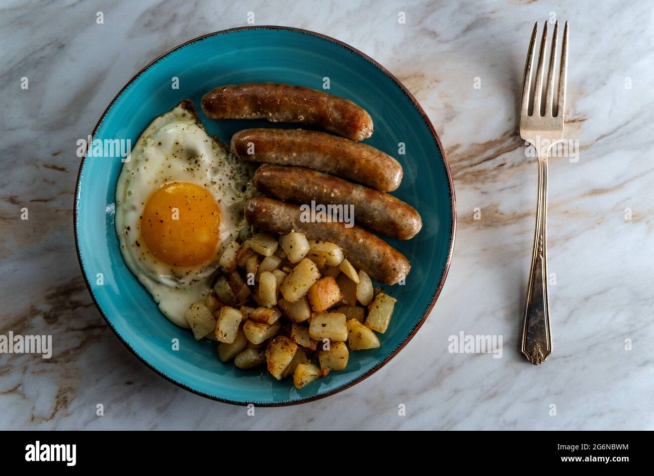 Fried sunny side up American egg breakfast with sausage and potatoes o