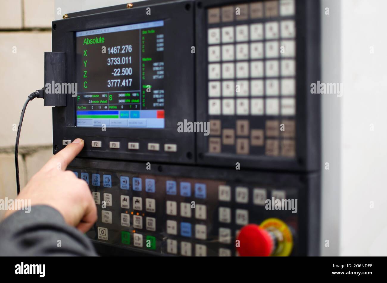 The process of programming a CNC machine. Entering data into a computer controlled machine, starting CNC engraving, control screen. Furniture manufact Stock Photo