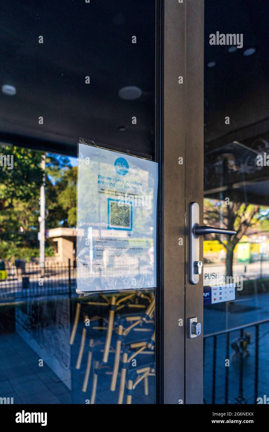 Reflections in windows of closed bar with QR checkin sign, in Balmain, Sydney Australia during pandemic lockdown Stock Photo