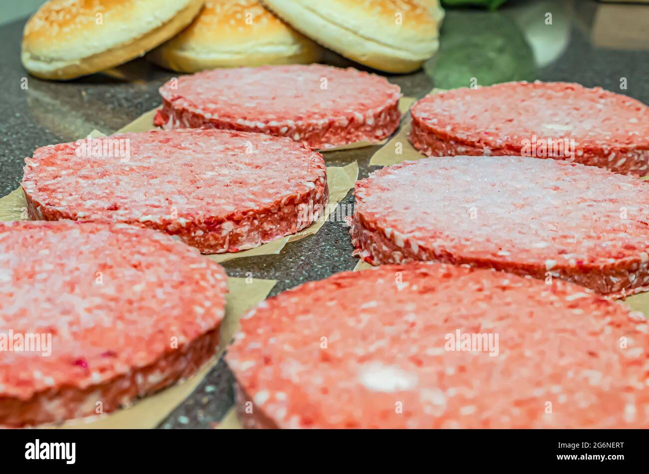 Frozen burger meat on table before grilling, defrost before grilling