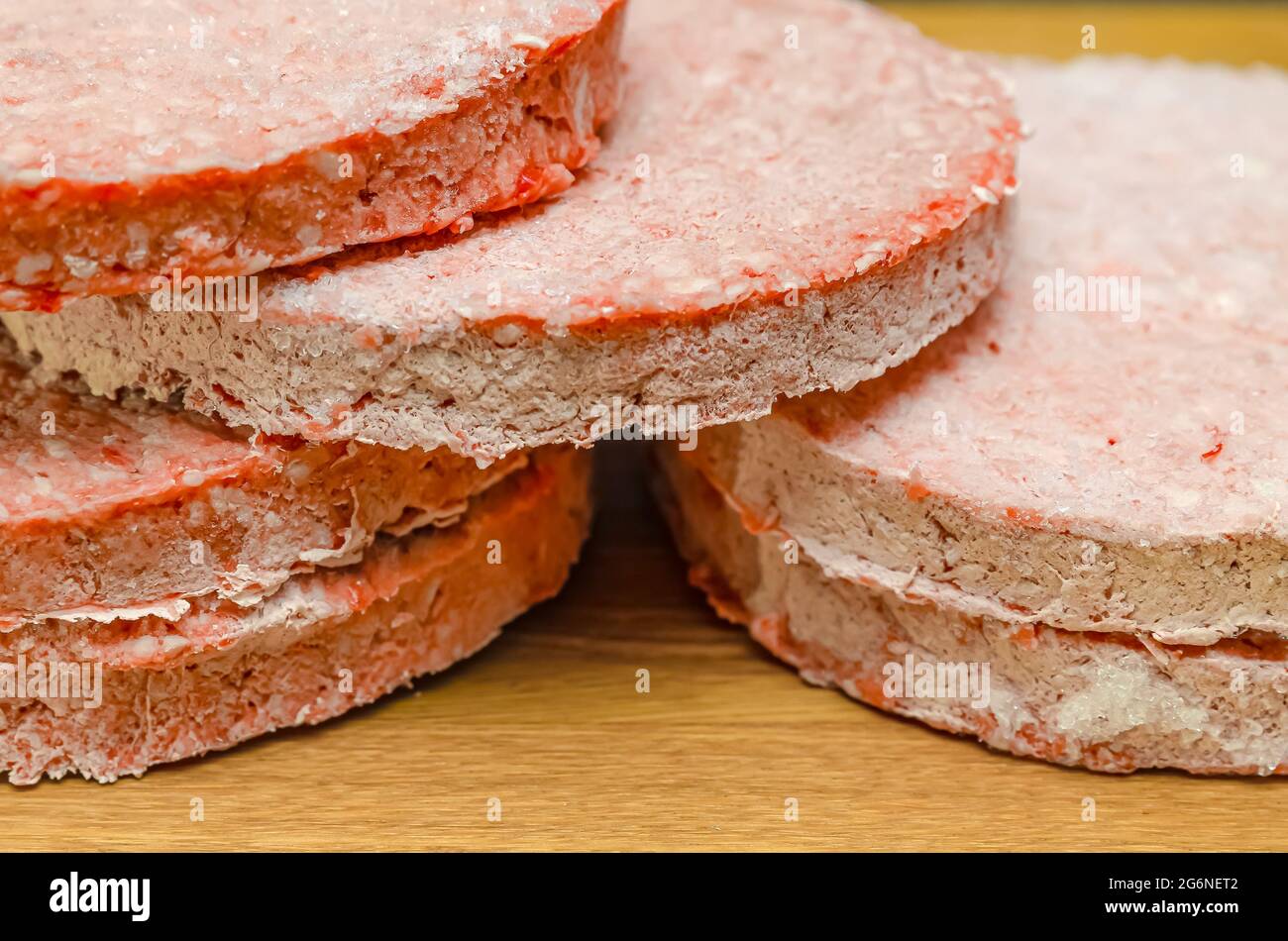 frozen beef hamburger patties, defrost before grilling, stacked on the