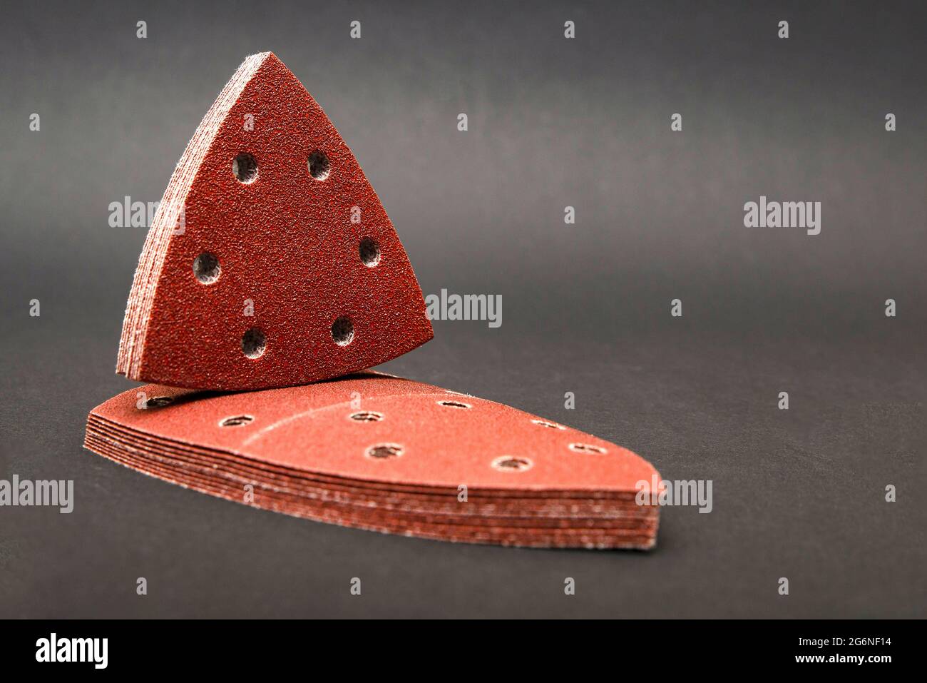 Sandpaper triangular shape, on a black background. For sanding wood and