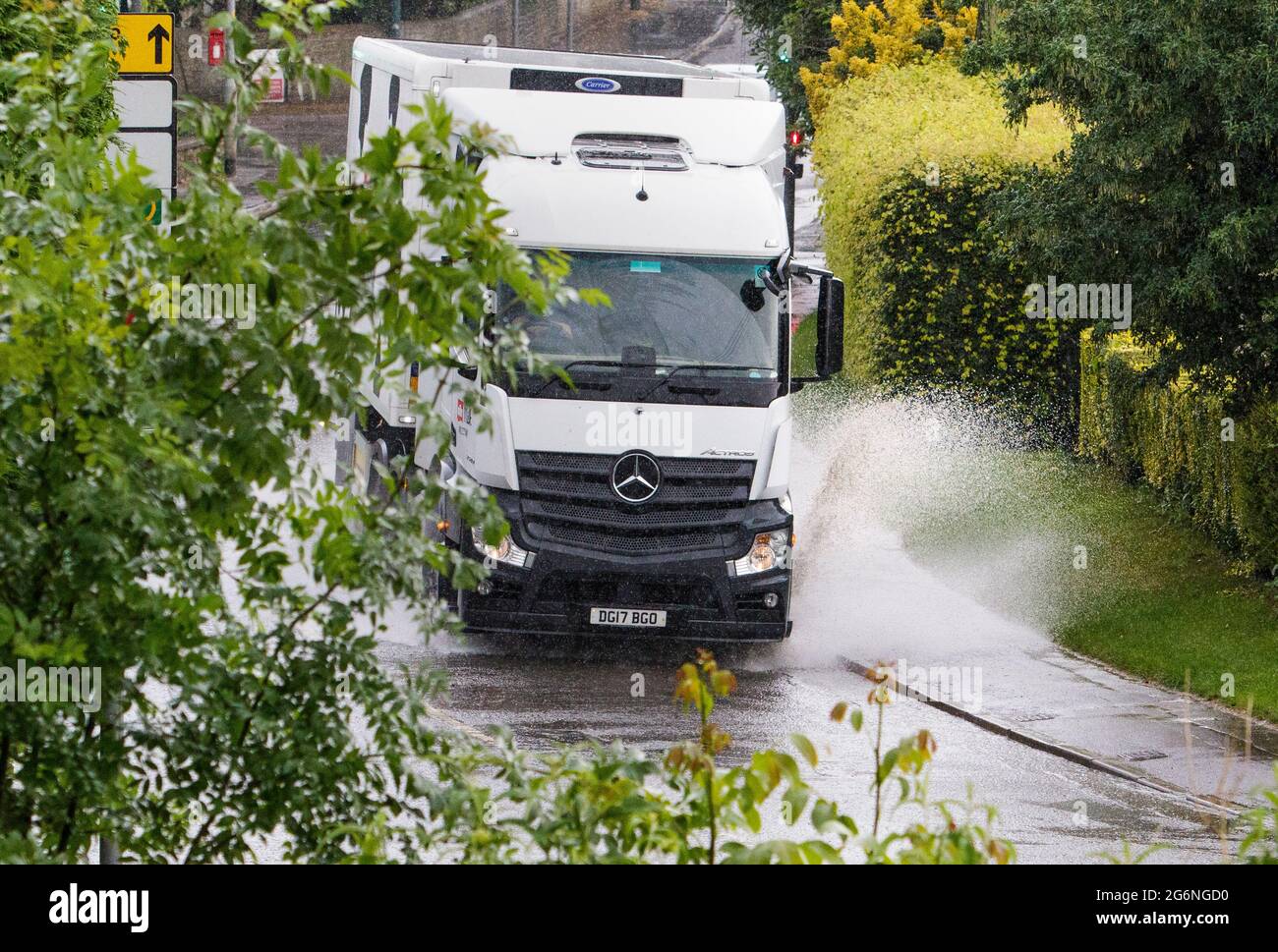 Chippenham, Wiltshire, UK. 7th July, 2021. Drivers are pictured braving torrential rain in Chippenham this evening as heavy rain showers once again make their way across Southern England. Credit: Lynchpics/Alamy Live News Stock Photo