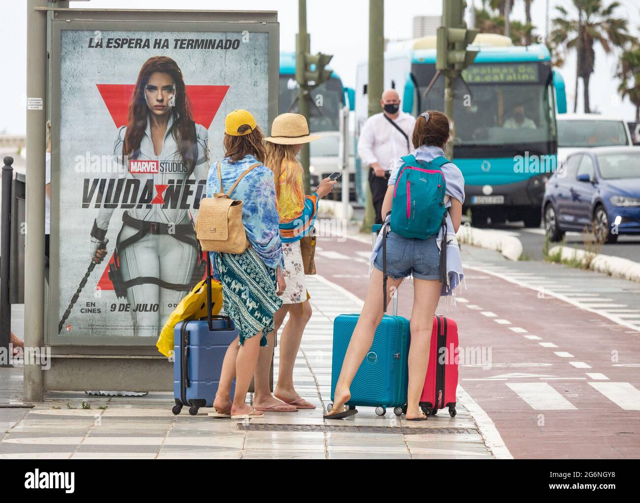 Las Palmas, Gran Canaria, Canary Islands, Spain. 7th July, 2021. Tourists  waiting for airport bus near the city beach in Las Palmas on Gran Canaria.  The Canary Islands, currently on the Amber