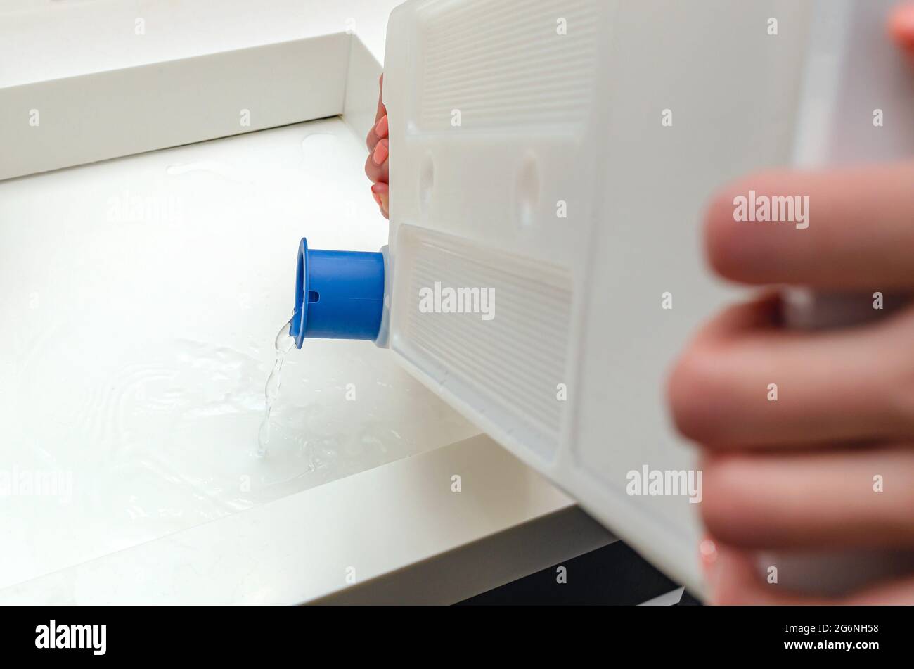 Condensate container from the dryer, a woman drains the accumulated