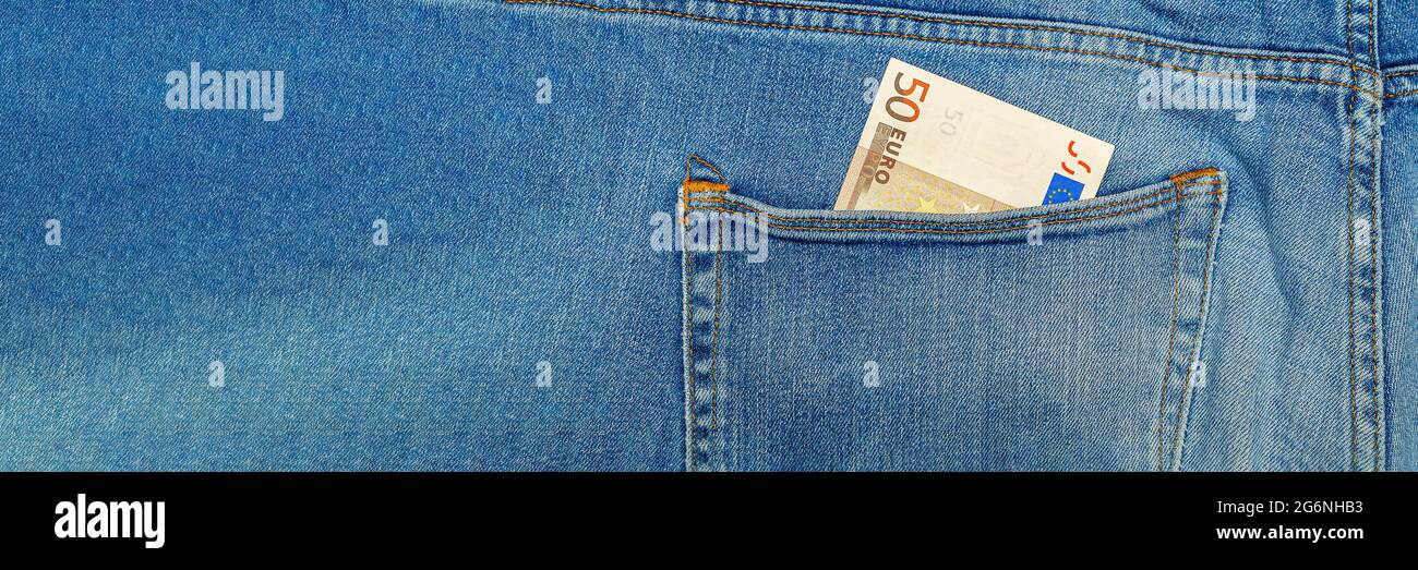Money in my jeans pocket, fifty Euros in the back pocket of blue jeans. Wealth and prosperity concept. Place for text. Copy space. Stock Photo